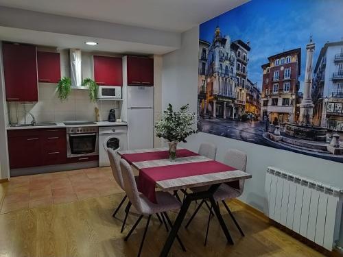 een keuken met een eettafel met een schilderij aan de muur bij Disfruta Teruel in Teruel