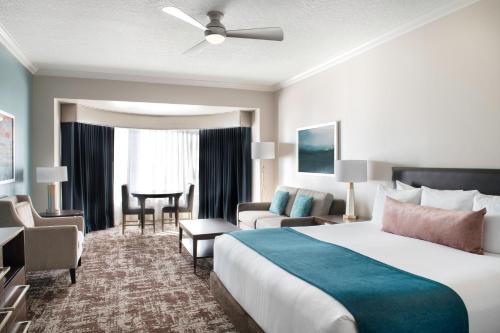 Habitación de hotel con cama grande y sala de estar. en Club Wyndham Harbour Lights, en San Diego