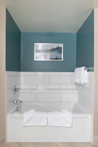 a bathroom with a white tub and a blue wall at Club Wyndham Harbour Lights in San Diego