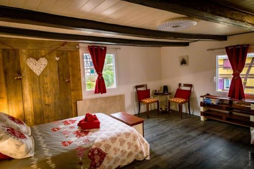 a bedroom with a bed and a table and chairs at Gîte Les Sabots de Paille, Alsace Haut-Rhin in Ballersdorf