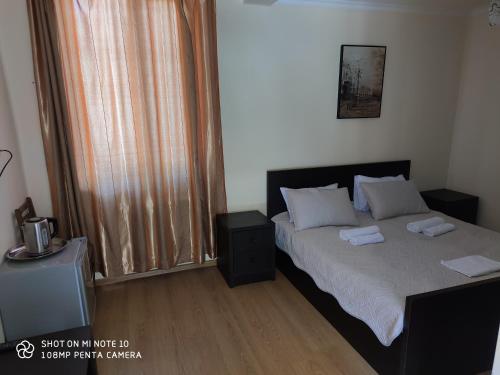 a bedroom with a bed with two towels on it at Borjomi Sichi in Borjomi