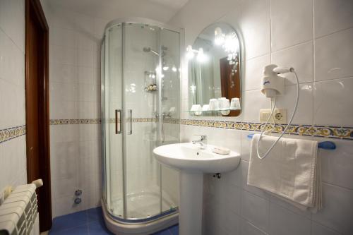 a bathroom with a glass shower and a sink at La Casona de Cardes in Cangas de Onís