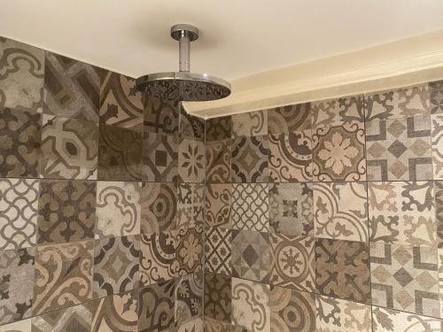 a bathroom with a tile wall with a chandelier at Prinsengracht Museum Bed and Breakfast in Amsterdam