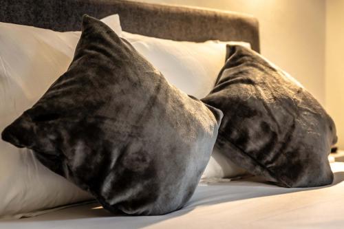 - un tas d'oreillers au-dessus du lit dans l'établissement La Dame de Coeur - 1 chambre, à Brive-la-Gaillarde