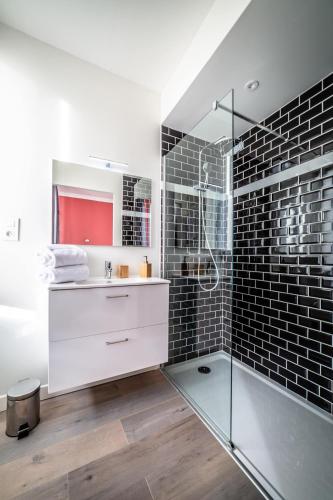 une salle de bain avec une douche en verre et un lavabo dans l'établissement Le Temps Éternel - 1 chambre, à Brive-la-Gaillarde