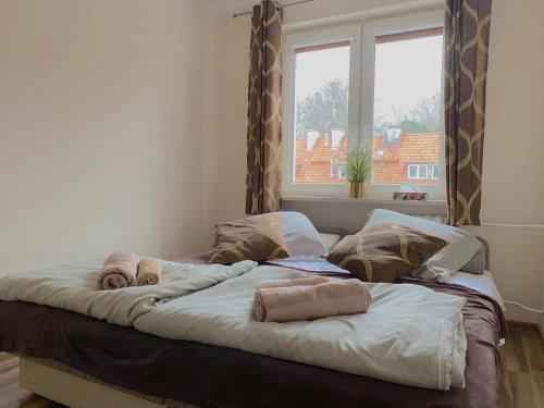 a large bed in a room with a window at Swish Apartment in Gdańsk