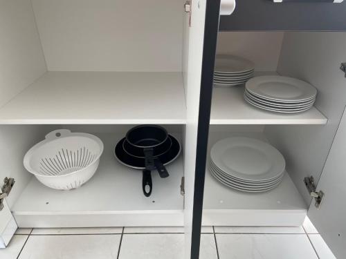 a white cabinet with plates and dishes on it at Apartment – Wohnung bei Nürnberg #2 in Röthenbach an der Pegnitz