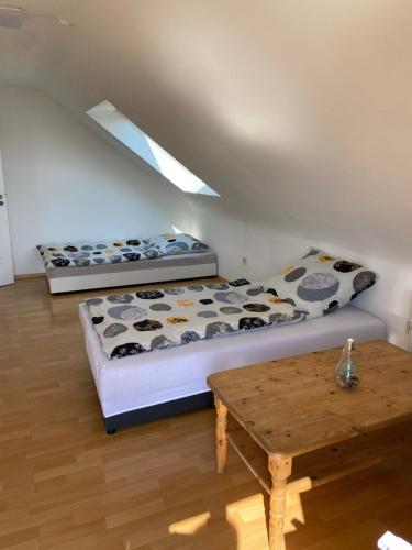 1 dormitorio con 2 camas y mesa de madera en Apartment – Wohnung bei Nürnberg #2 en Röthenbach an der Pegnitz