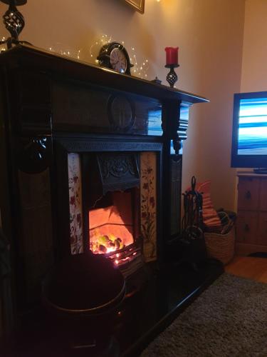 a fireplace with a fire in it in a living room at Relaxing Break in the Countryside in Foyle Bridge