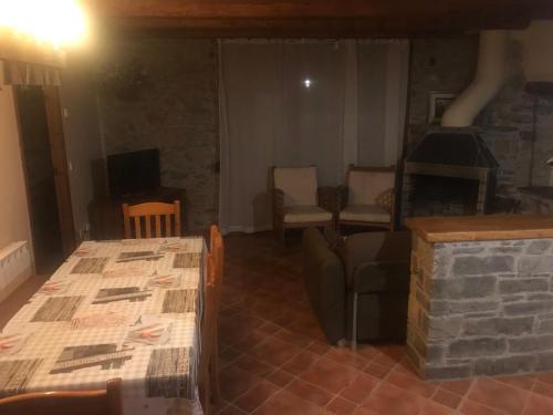 a living room with a table and a stone fireplace at Roch Hotel in Altrón
