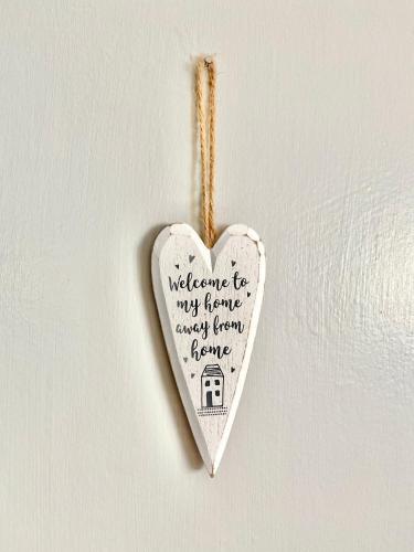a white heart ornament hanging on a wall at Hiraeth Môn in Menai Bridge