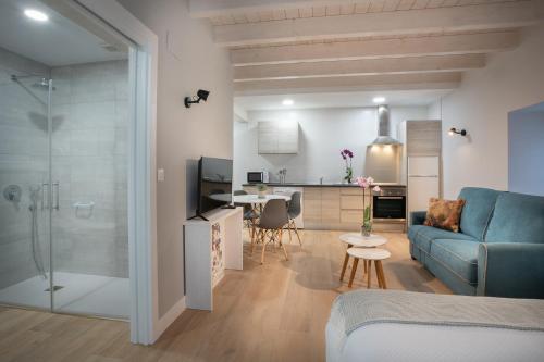 sala de estar con sofá azul y cocina en Apartamentos Hondarmendi, en Guernica y Luno