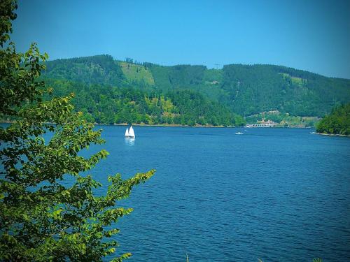 a sailboat in the middle of a large lake at Meister BÄR HOTEL Frankenwald in Berg