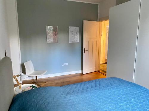 a bedroom with a blue bed and a white door at Zentrumsnahe schöne Altbauwohnung bis 4 Personen in Flensburg