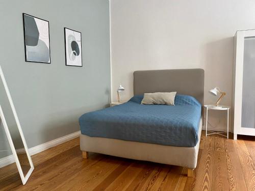 a bedroom with a bed with a blue comforter at Zentrumsnahe schöne Altbauwohnung bis 4 Personen in Flensburg