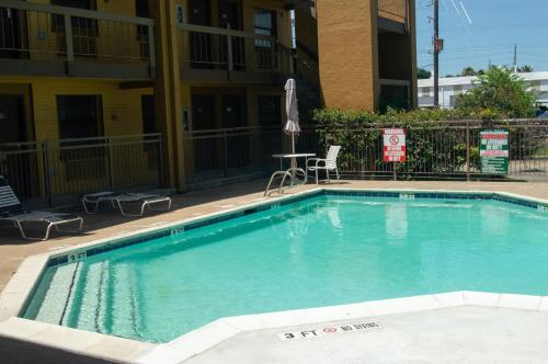 a swimming pool in front of a apartment building at America's Inn Houston/Stafford /Sugarland in Houston