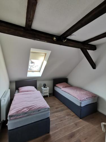 two beds in a attic bedroom with wooden beams at FeWo Rohleder de mit 130m2 und Garten für 6Pers mit 2 Bad in Cottbus