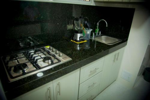 a kitchen counter with a stove and a sink at Apartamento Rodadero a media cuadra de la playa in Puerto de Gaira