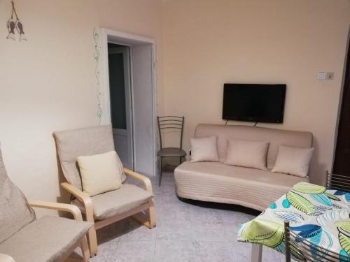 - un salon avec un canapé, une télévision et des chaises dans l'établissement Casa Milena, à Rio Marina