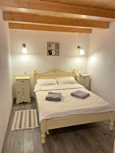 a bedroom with a bed with two towels on it at Cabana din Groapa Frumoasa in Râşnov