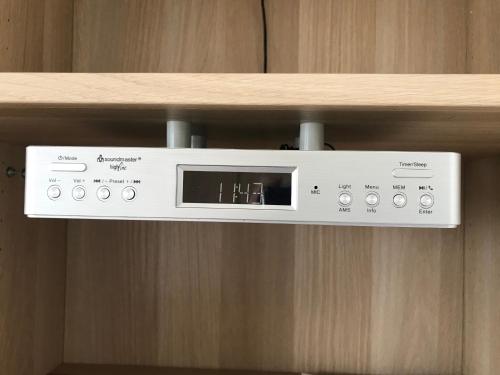 a microwave on a shelf on a wooden wall at B&B De Spiegel - Genieten van rust en ruimte in Cothen