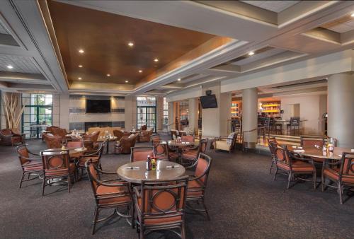 a restaurant with tables and chairs and a bar at Orange Tree Resort in Scottsdale