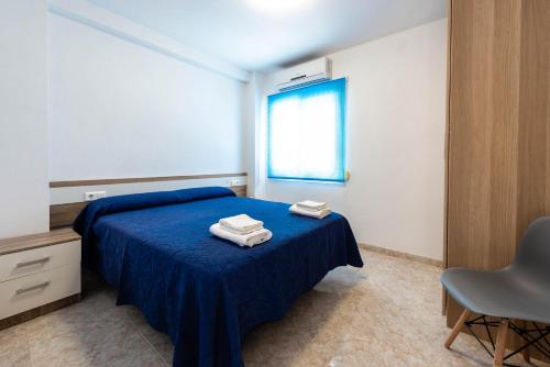 a bedroom with a blue bed with two towels on it at EDIFICIO CHAPARIL in Nerja