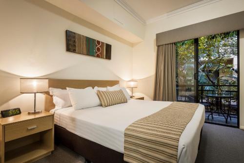 a hotel room with a large bed and a large window at Best Western Northbridge Apartments in Perth