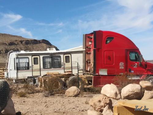 een rode en witte truck geparkeerd naast enkele rotsen bij Camping at Desert Gardens Oasis at Lobo, Texas in Van Horn
