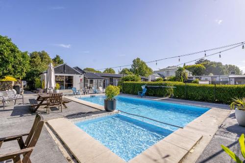 a swimming pool in the backyard of a home at Amble Inn Motel in Masterton