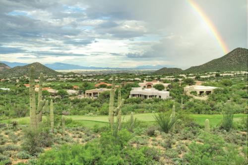 a rainbow over a valley with houses and trees at Starr Pass Golf Suites in Tucson