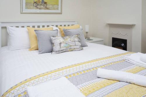 a large white bed with many pillows on it at Cornwallis House in Oxford