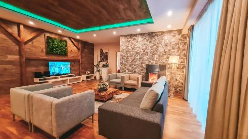a living room with two couches and a tv at Hotel Crocus in Vysoke Tatry - Strbske Pleso