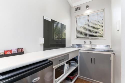 a kitchen with a counter and a sink and a window at Amble Inn Motel in Masterton