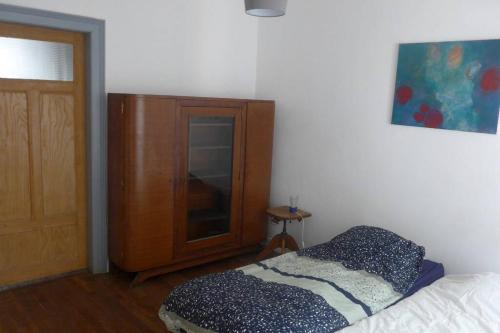 Un dormitorio con una cama y un armario de madera. en gite herbes folles, en Lutzelbourg