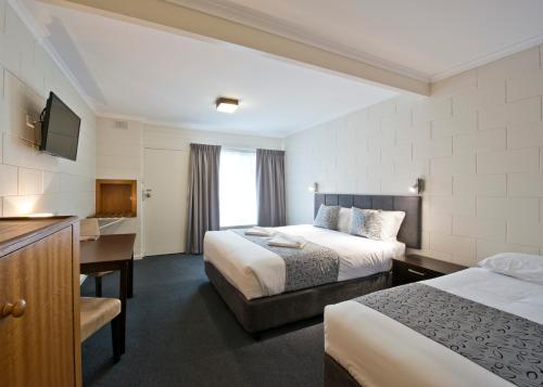 A bed or beds in a room at Victor Harbor City Inn