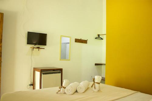 Habitación con cama, TV y toallas. en Pousada Cavalo Marinho, en Arraial d'Ajuda