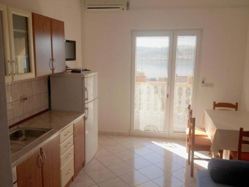 een keuken met een wastafel en een tafel met een tafel bij Apartment in Rtina/Zadar Riviera 8160 in Miočić