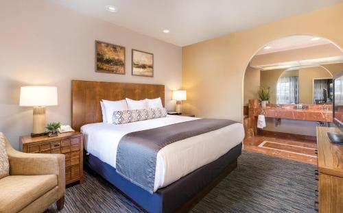 a bedroom with a bed and a chair and a bathroom at The Legacy Golf Resort in Phoenix