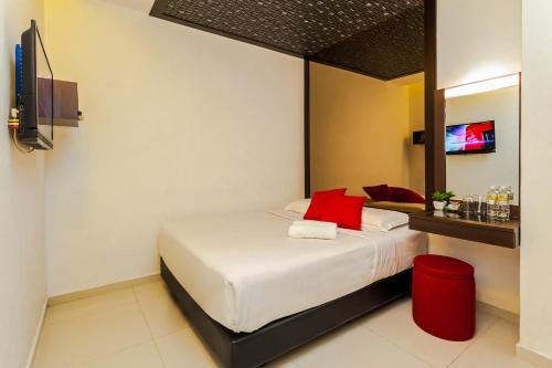 a bedroom with a bed with red pillows at Time Hotel Sunway in Petaling Jaya