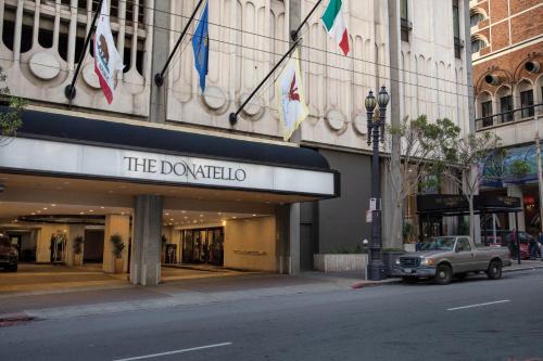 a car parked in front of a building with flags at The Donatello Hotel in San Francisco