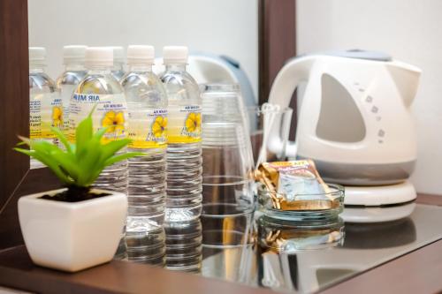um balcão com garrafas de água e um vaso de plantas em Time Hotel Sunway em Petaling Jaya