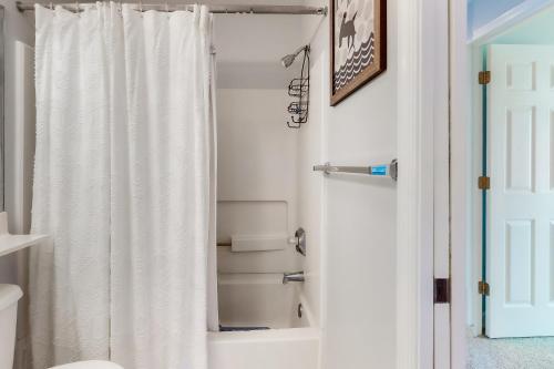 een badkamer met een douche met een wit douchegordijn bij Sea Colony - 54049 Seashell in Bethany Beach