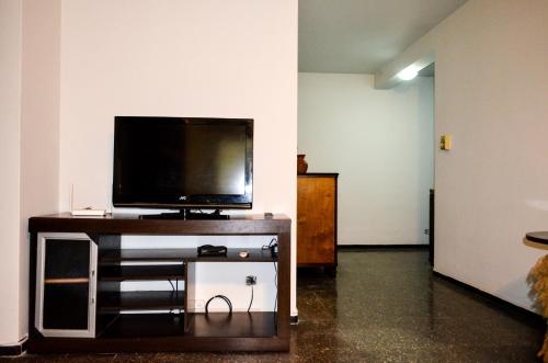 sala de estar con Tv LED en un soporte en Depto cómodo a metros del Parque y Av. Arístides en Mendoza