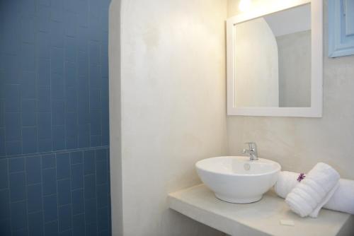 une salle de bain avec un lavabo et un miroir dans l'établissement Villa Maria Rooms, à Akrotiri
