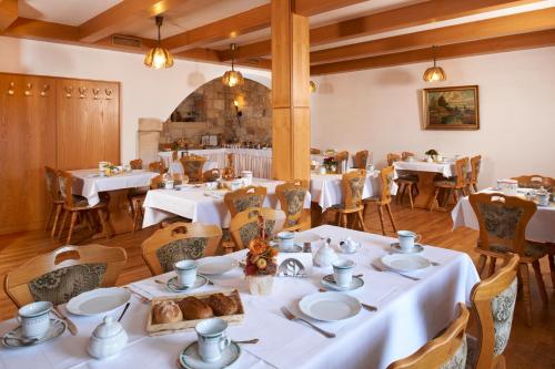 une salle à manger avec des tables et des chaises blanches dans l'établissement Landhotel Zum Erbgericht, à Stolpen