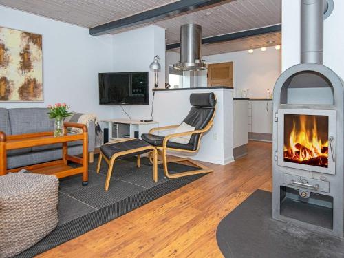 ノーポにある4 person holiday home in Nordborgのリビングルーム(暖炉、ソファ付)