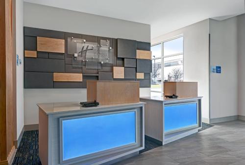 a lobby with two reception desks with blue screens at Holiday Inn Express & Suites Memorial – CityCentre by IHG in Houston