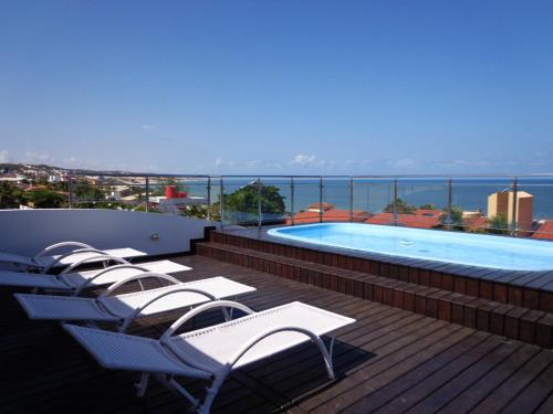 una fila de sillas sentadas en una terraza junto a una piscina en Residence Victoria Brasil, en Natal