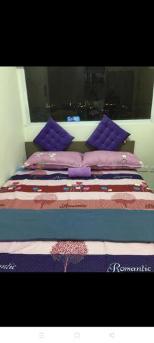 - un lit avec des oreillers violets et une couette dans l'établissement Urban Deca Tower Graceysplace Unit unit 3113 Mandaluyong, à Manille